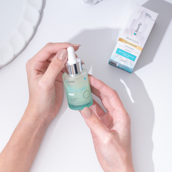 Mãos segurando o sérum rejuvenescedor Fleurity